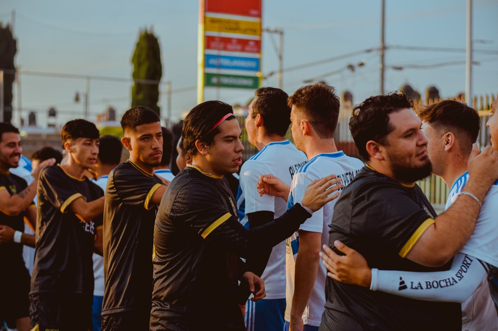Jogadores de futebol de duas seleções diferentes em um momento de intensa disputa em campo, com a torcida ao fundo em um estádio lotado, refletindo a importância tática de um empate.