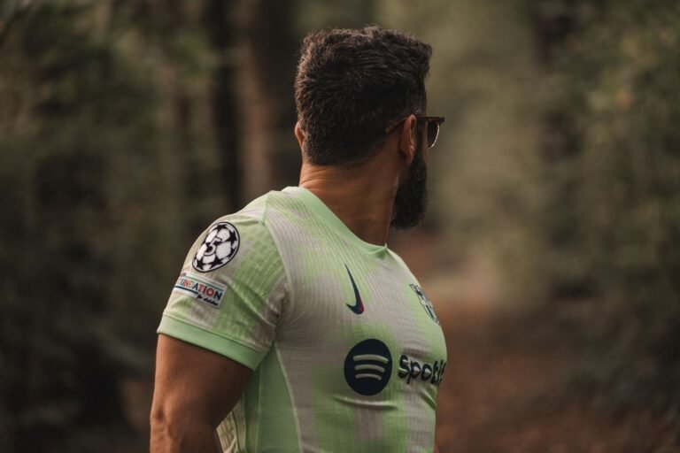 Jogador de futebol em estádio, olhando para o logotipo de um time europeu com um acordo de transferência na mão.