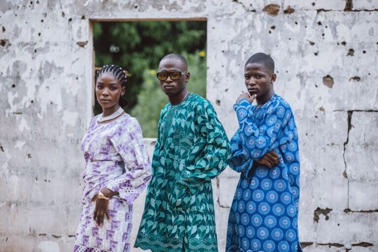 Jogadores de uma seleção africana de futebol chegando em grupo, com ênfase em seu estilo e identidade cultural fora de campo, em um aeroporto ou entrada de hotel.