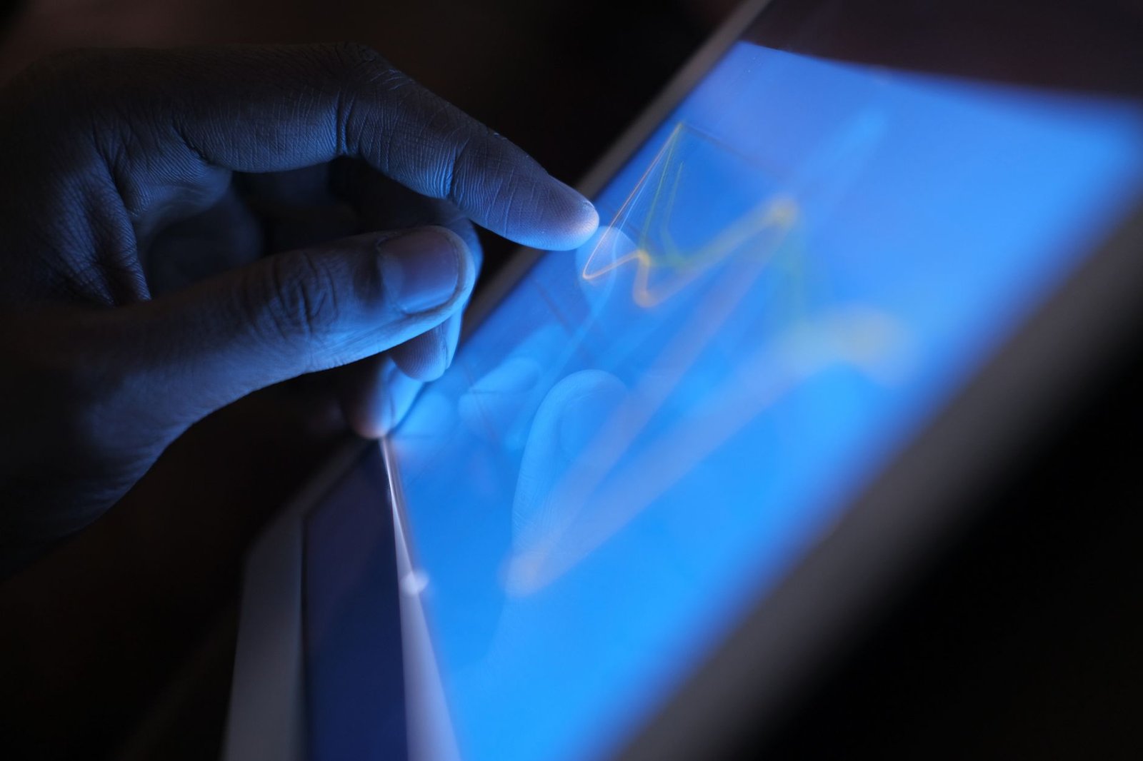 Jogadores de futebol ou treinadores analisando intensamente telas digitais táticas avançadas em uma sala de treinamento futurista, com foco em planejamento estratégico e tecnologia moderna.