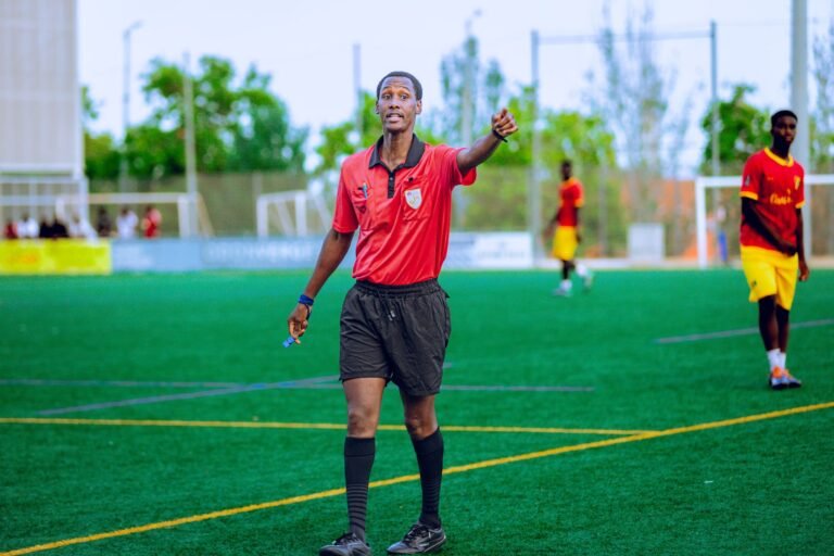 Árbitro de vídeo em um estádio de futebol, cercado por jogadores e técnicos, discutindo uma decisão polêmica durante um jogo de alto risco da Copa do Mundo.