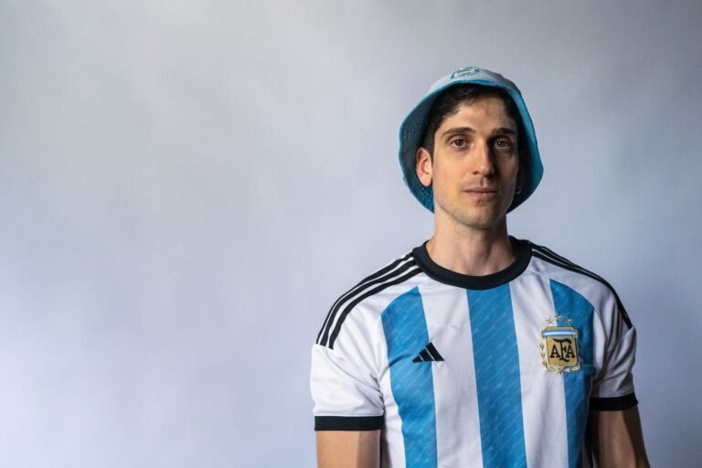 Time de futebol argentino celebrando vitória em estádio lotado, jogadores levantando mãos, confete caindo, torcedores aplaudindo