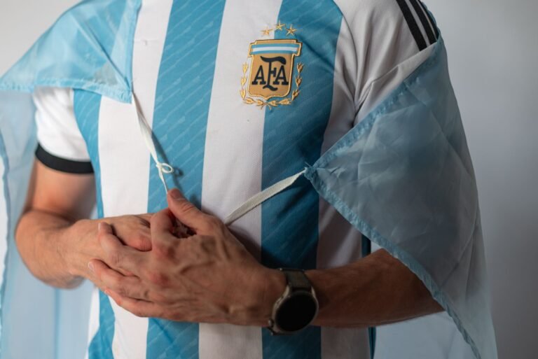 Fãs de futebol argentinos comemorando em um estádio, com bandeiras e confete, celebrando a vitória na Copa do Mundo.