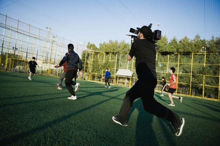 Treino de futebol em campo de treinamento, jogadores aquecendo e técnico analisando tática