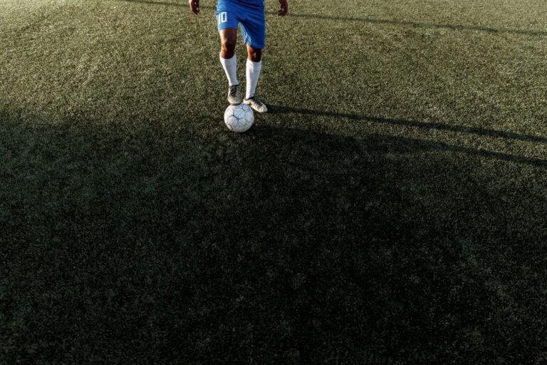 Jovem jogador de futebol em ação no campo de um estádio lotado durante uma partida de futebol