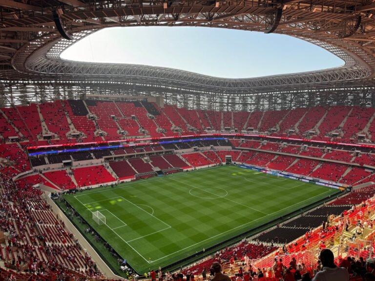 Estádio de futebol moderno nos Estados Unidos lotado de torcedores, com bandeira americana em destaque, simbolizando o interesse do país em sediar a Copa do Mundo de Clubes de 2029.