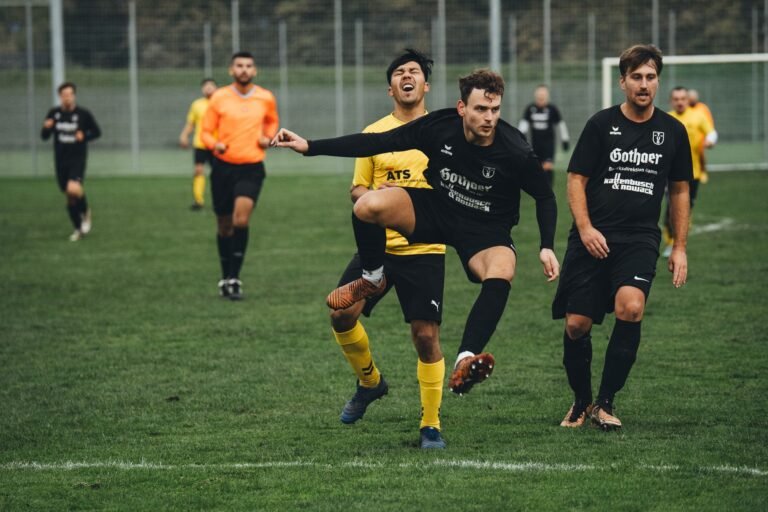 Jogador de futebol em ação no campo, com a torcida vibrando ao fundo